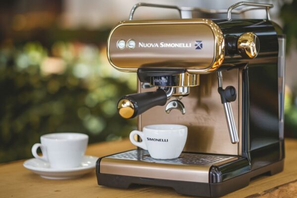 A sleek Nuova Simonelli espresso machine brewing a rich espresso shot in a café setting.