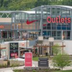 Outlets at the Dells featuring a vibrant shopping scene with stylish storefronts and happy shoppers.