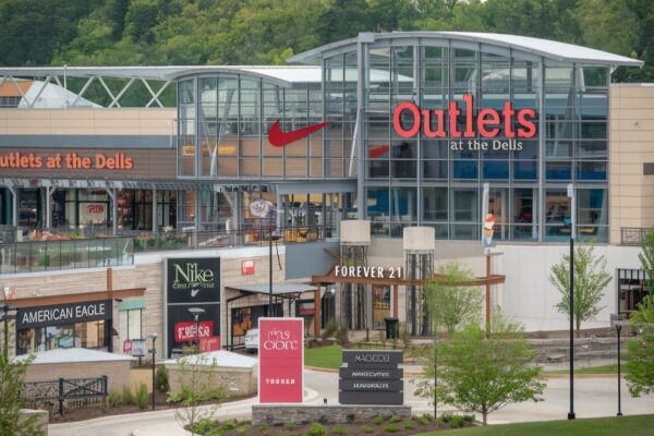 Outlets at the Dells featuring a vibrant shopping scene with stylish storefronts and happy shoppers.